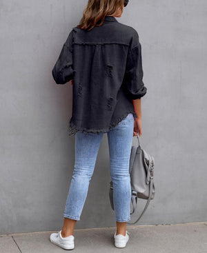 Back view of the Black oversized Y2K jacket with frayed hem, worn with skinny jeans and white sneakers
