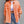 Orange frayed denim jacket with ripped details, close front view of the raw edged pockets and buttons