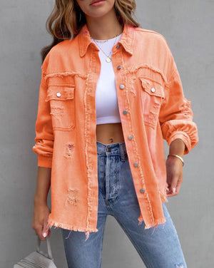 Orange frayed denim jacket with ripped details, close front view of the raw edged pockets and buttons
