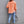 Back view of the Orange distressed shacket with a curved frayed hem and frayed yoke seam