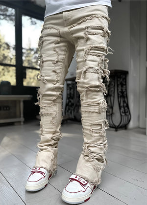 Gräddvit färgvariant på modell, fransiga lappar från låret och nedåt och uppvikt benslut över röd-vita skor
