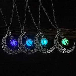 Four Glowing Moon Y2K Necklaces hanging in the dark, glowing purple, blue, light blue and green