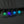 Four Glowing Moon Y2K Necklaces lit up against a grey wall in green, purple, blue and light blue