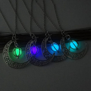 Four Glowing Moon Y2K Necklaces lit up against a grey wall in green, purple, blue and light blue