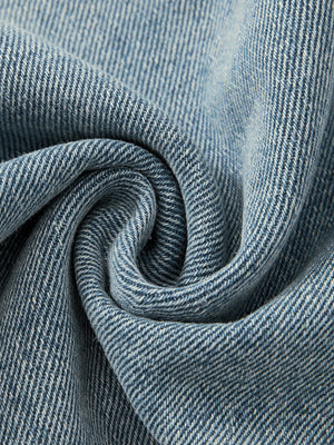 The light blue denim twisted to show its diagonal twill weave, a 470 gsm cotton and polyester blend