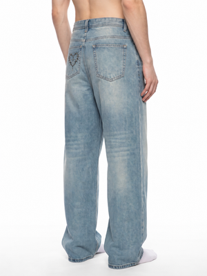 Back view on the model, plain washed seat with a barbed heart motif on one of the back pockets