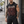 A tattooed model wears the washed black hooded muscle shirt in the street, hood down, with black shorts