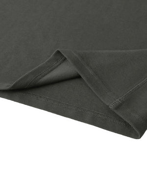 Corner of the hem turned back, double-stitched, showing the reverse of the ribbed knit