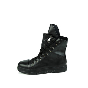 Black high top boot alone on white, three-quarter view of the glossy upper, laces and side zip