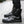 Black high top techwear boots worn on a paved street, glossy finish and folded collar