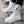 White high top sneaker boots worn on stone steps, zip open at the side and tall collar