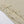 Close-up of the pointed ruffles running down the slit of the khaki mesh dress, laid flat on a white table