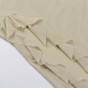 Close-up of the pointed ruffles running down the slit of the khaki mesh dress, laid flat on a white table