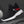 Black mesh techwear sneaker on a dark background, sock collar, red stripes and white sole