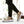 Khaki knit sneakers worn with black joggers, mid-step outdoors, black stripes on the side