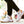 White knit mesh sneakers with orange stripes worn with black joggers, walking outdoors