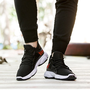 Man wearing Black knit mesh sneakers and black joggers, front view of both shoes