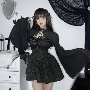 Γυναίκα φορά το Lace Bow Goth Top πάνω από μαύρο φόρεμα, μπροστινή όψη, με φαρδιά διάφανα μανίκια καμπάνα ανοιχτά