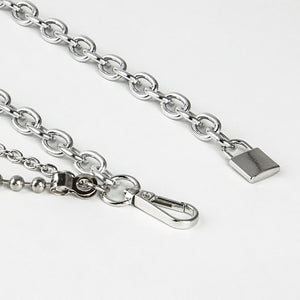 Close-up van de zilverkleurige kettingriem met de hangslothanger, de karabijnhaak en de dikke schakelketting