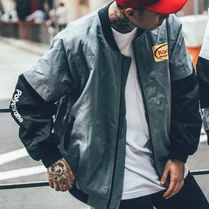 Man wearing the grey Layered Sleeve Baseball Bomber Jacket open over a white tee, front view in the street