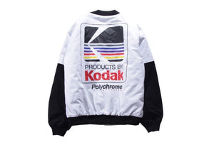 White layered sleeve baseball bomber jacket laid flat, back view with the graphic print and black sleeves