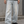 Cropped front view of the light wash baggy jeans worn with a dark tee, wide legs stacking over sneakers