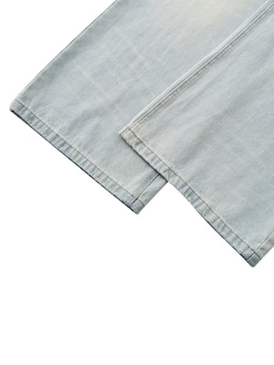 Close-up of the wide leg hems of the light wash jeans laid crossed, straight stitched edges in pale blue denim