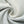 Light wash denim twisted into a spiral, close-up of the diagonal twill of the baggy jeans fabric in pale blue