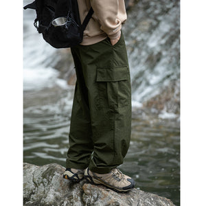 Dark army green Loose Nylon Cargo Pants, model with a backpack, large flap pocket on the side of the leg