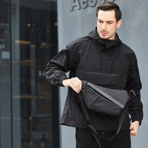 Magnetic Clasp Techwear Sling worn by a man in black, insets of the outer port and inner power bank cable