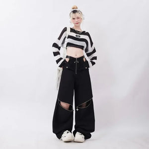 Person wearing a black and white striped sweater and black pants on a white background