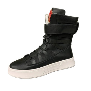 Black high-top sneaker with white sole on a gray surface