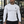 A man stands in a gym in the white compression shirt with black trousers, the small chest logo