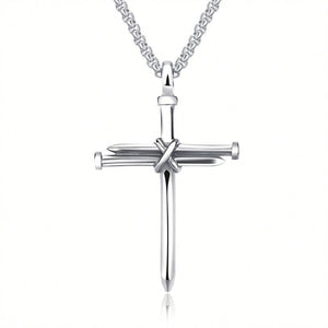 Zilverkleurige spijkerkruishanger aan een schakelketting, drie spijkers samengebonden met een gekruiste draad in het midden, witte achtergrond