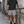 Model in the Light Gray athletic shorts and a black tee resting a hand on a railing in a narrow street