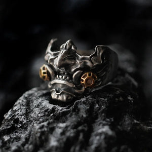 Antiqued metal ring shaped as a horned oni mask with gold accents
