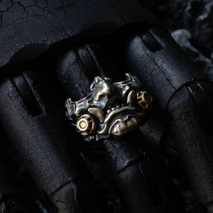 Antiqued metal ring shaped as a horned oni mask with gold accents