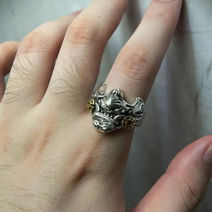 Antiqued metal ring shaped as a horned oni mask with gold accents