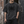 Man in the Black oversized acid wash tee by a brick doorway, front view with the dark thorn graphic