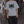 Man leaning on a graffiti wall in the Light Gray acid wash tee, front view with the black spiky print