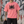 Man in the Pink acid wash graphic tee holding a cap by a graffiti wall, front view of the oversized fit