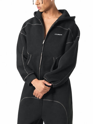 Black zip up hoodie half open on a model, three-quarter view of the drop shoulders and white CYBER logo