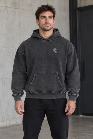 Model in the black oversized cyberpunk graphic hoodie, front view, small marbled chest logo and kangaroo pocket