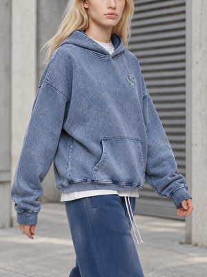 Kobieta idąca w jasnoniebieskiej bluzie oversize w stylu cyberpunk, widok z przodu na długie, obszerne rękawy