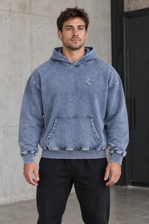 Model w jasnoniebieskiej bluzie oversize snow wash, widok z przodu, opadające ramiona i szeroki krój