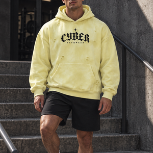 Man in the Yellow oversized distressed hoodie on concrete gym steps, black shorts and white sneakers