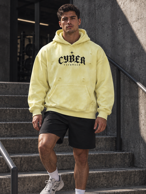 Man in the Yellow oversized distressed hoodie on concrete gym steps, black shorts and white sneakers