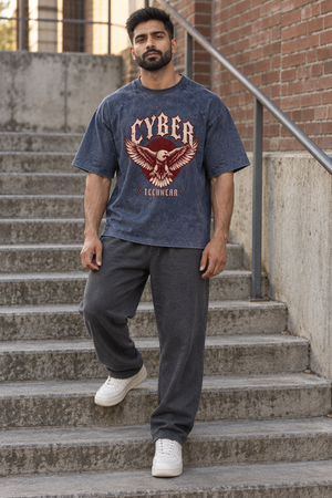Mand går ned ad trapper i den marineblå t-shirt med mineralvask, set forfra med CYBER TECHWEAR-ørnen