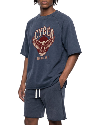 Mand i den marineblå oversized raglan-T-shirt, set på skrå med den ene hånd i shortslommen