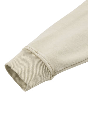 Detail of an Apricot hoodie sleeve ending in a ribbed cuff, with the dropped shoulder seam in a relaxed fold